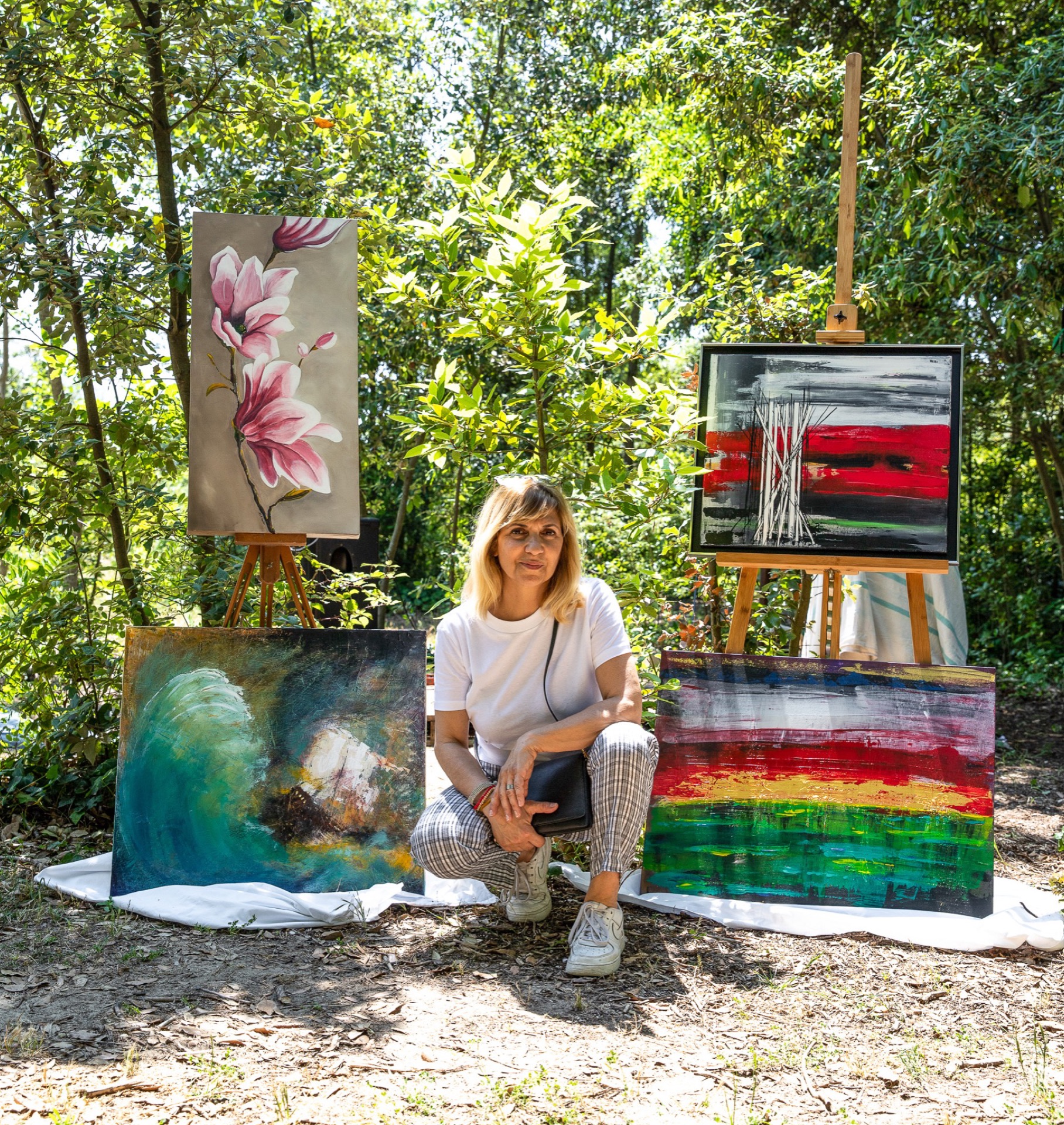 Artist with her paintings outdoors