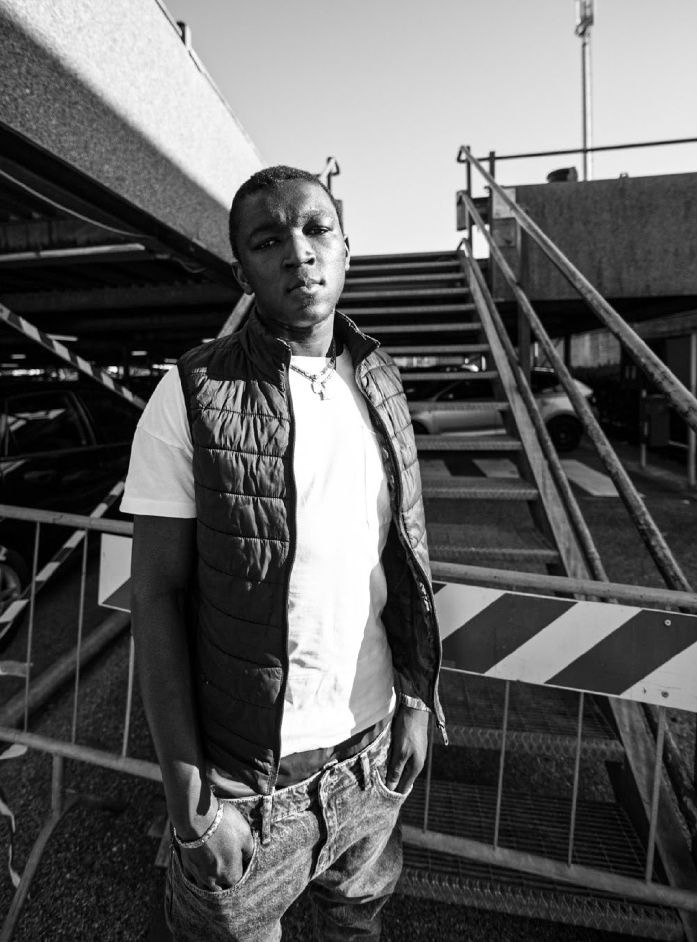 Young man urban portrait in front of a staircase, black and white