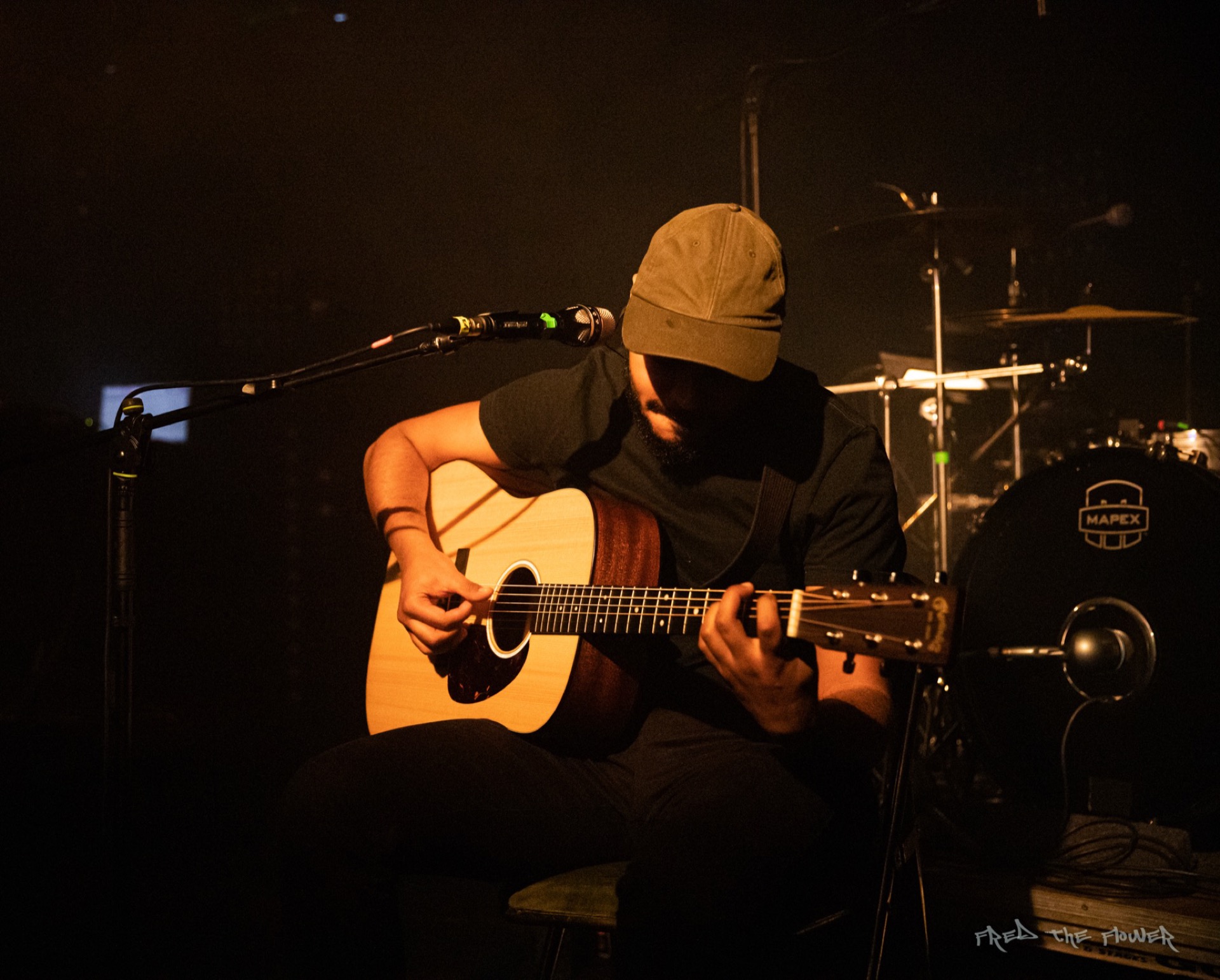 Guitarist performing acoustic, warm stage light