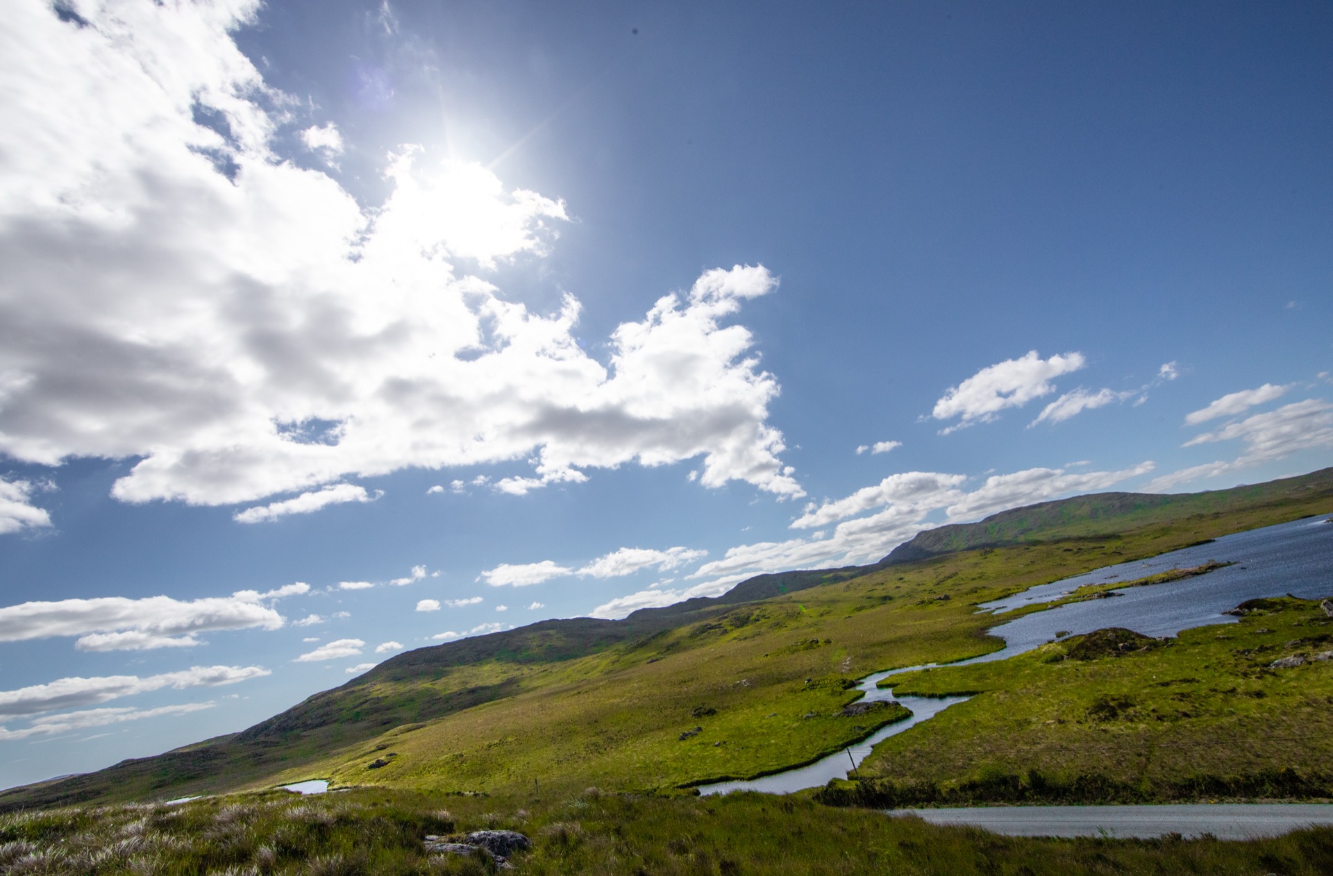 Green hills and winding road under a wide sky, Ireland