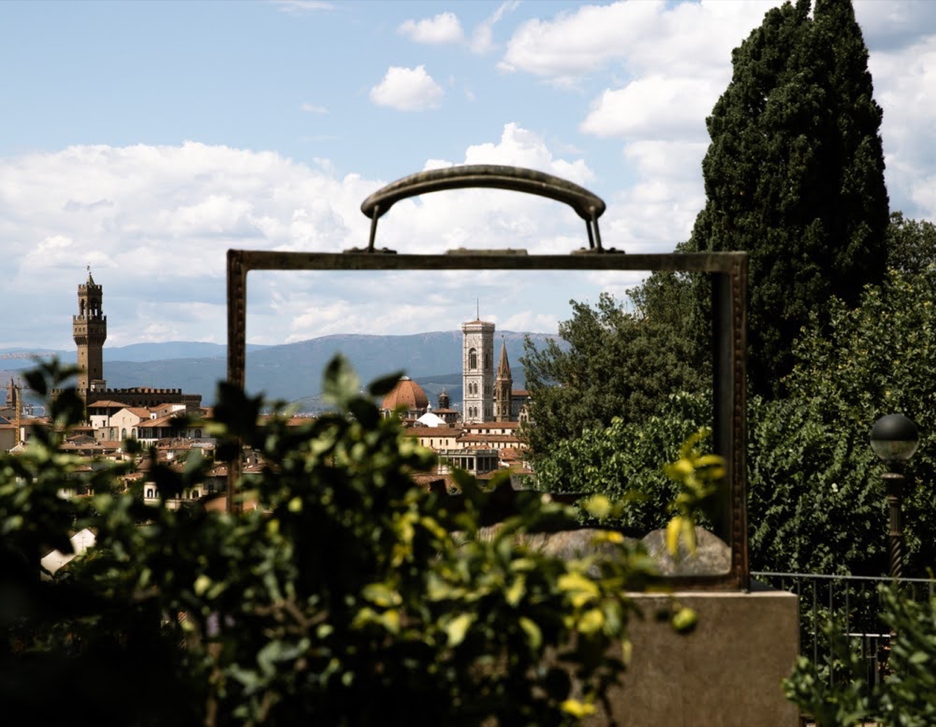 Florence skyline with Palazzo Vecchio framed through an iron sculpture