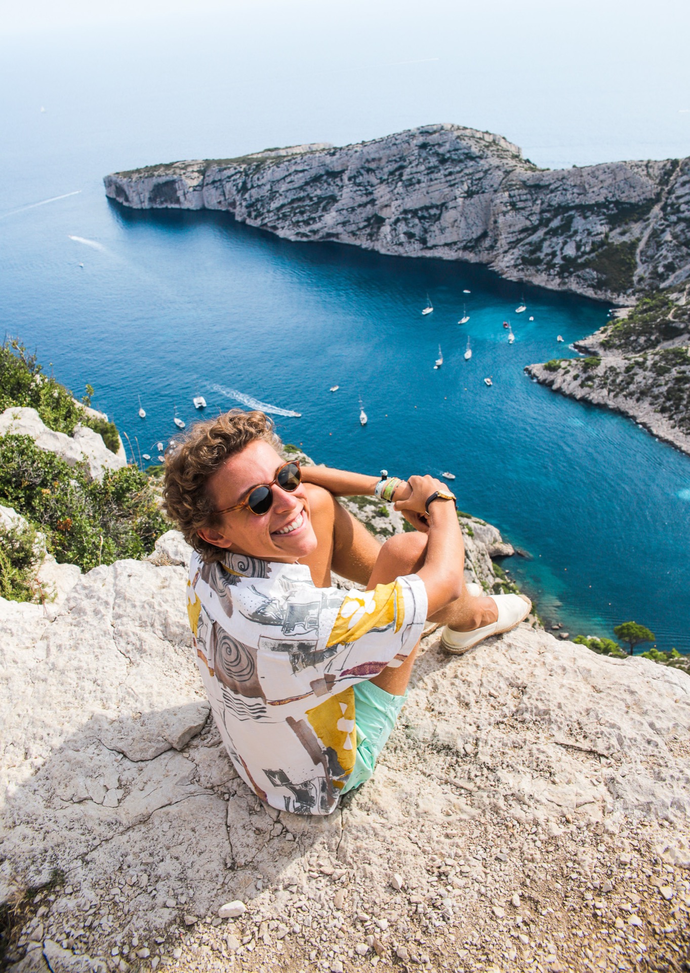 Man overlooking a Mediterranean bay from a cliff