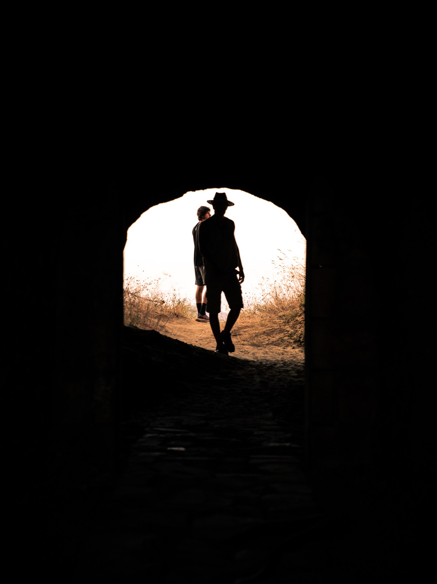 Silhouette through an arched tunnel