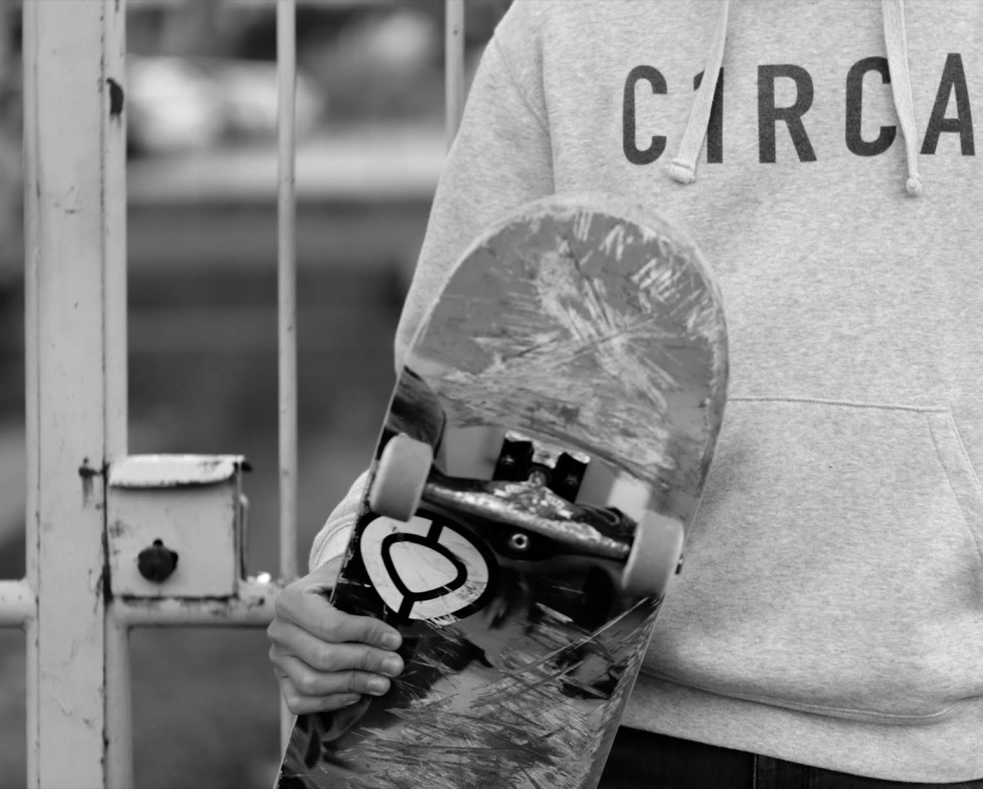 Skateboarder holding a skateboard, black and white