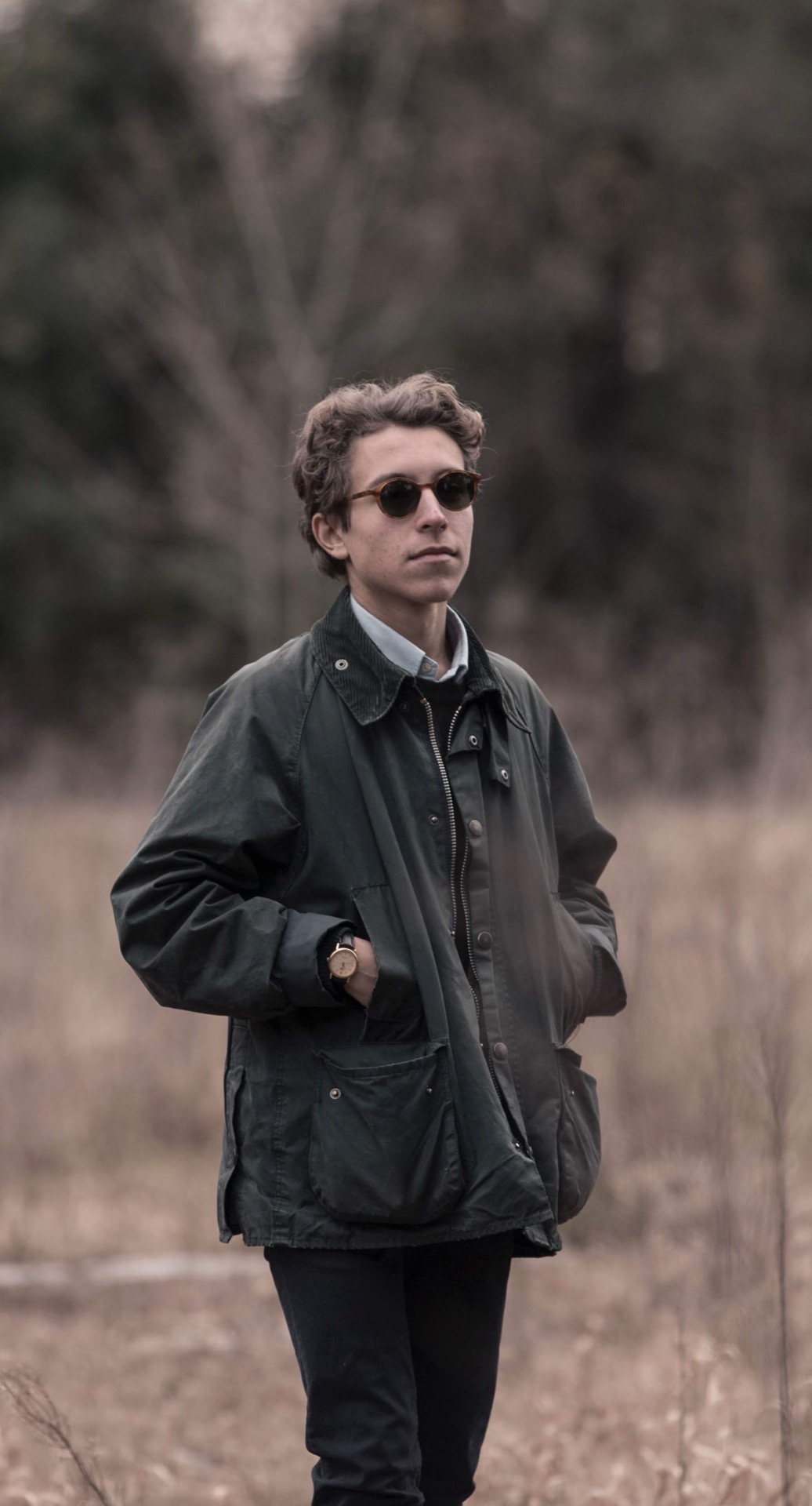 Young man with sunglasses in a dry autumn field