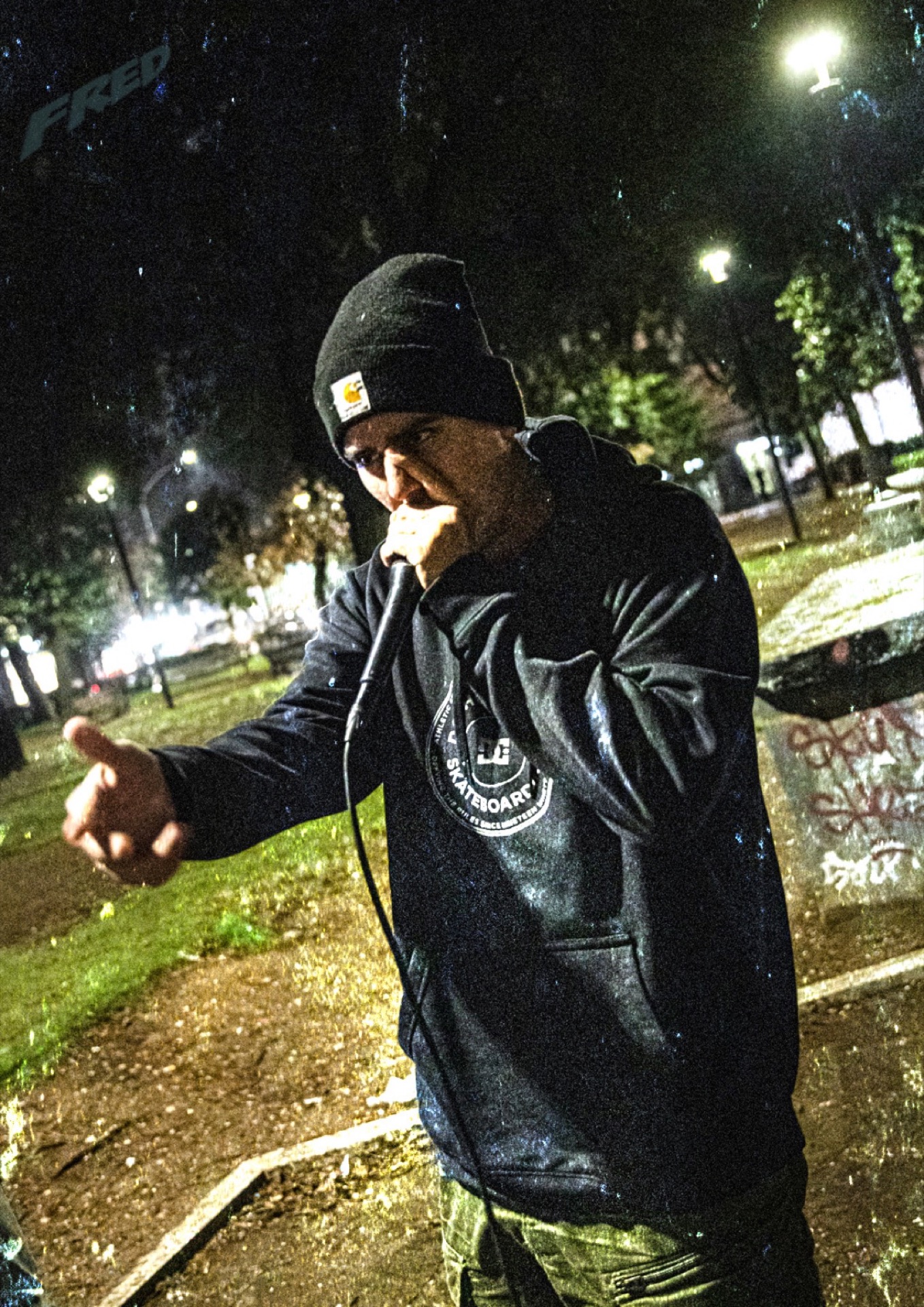 Rapper performing outdoors at night in the rain