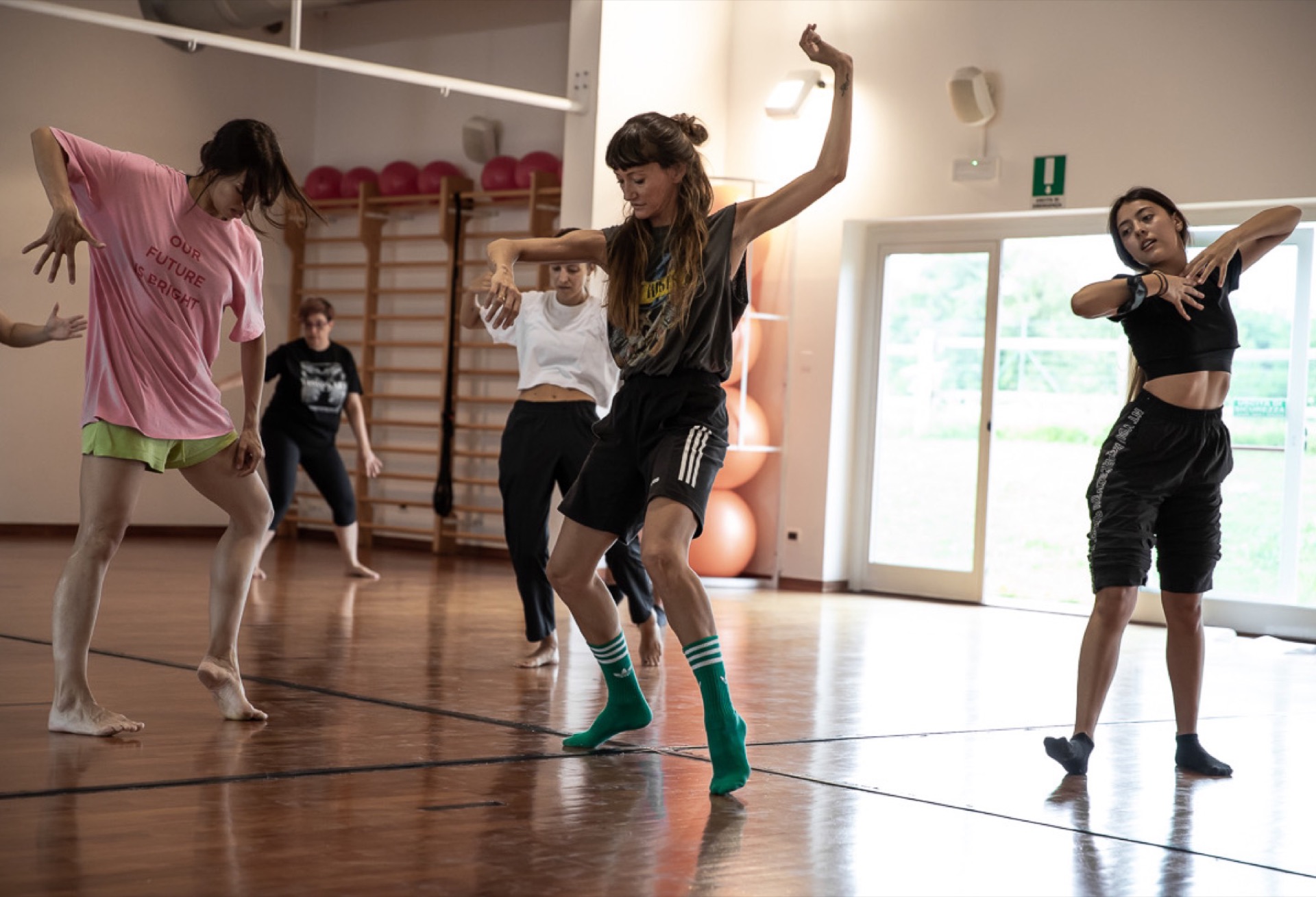 Dance rehearsal in a gym, multiple dancers in motion