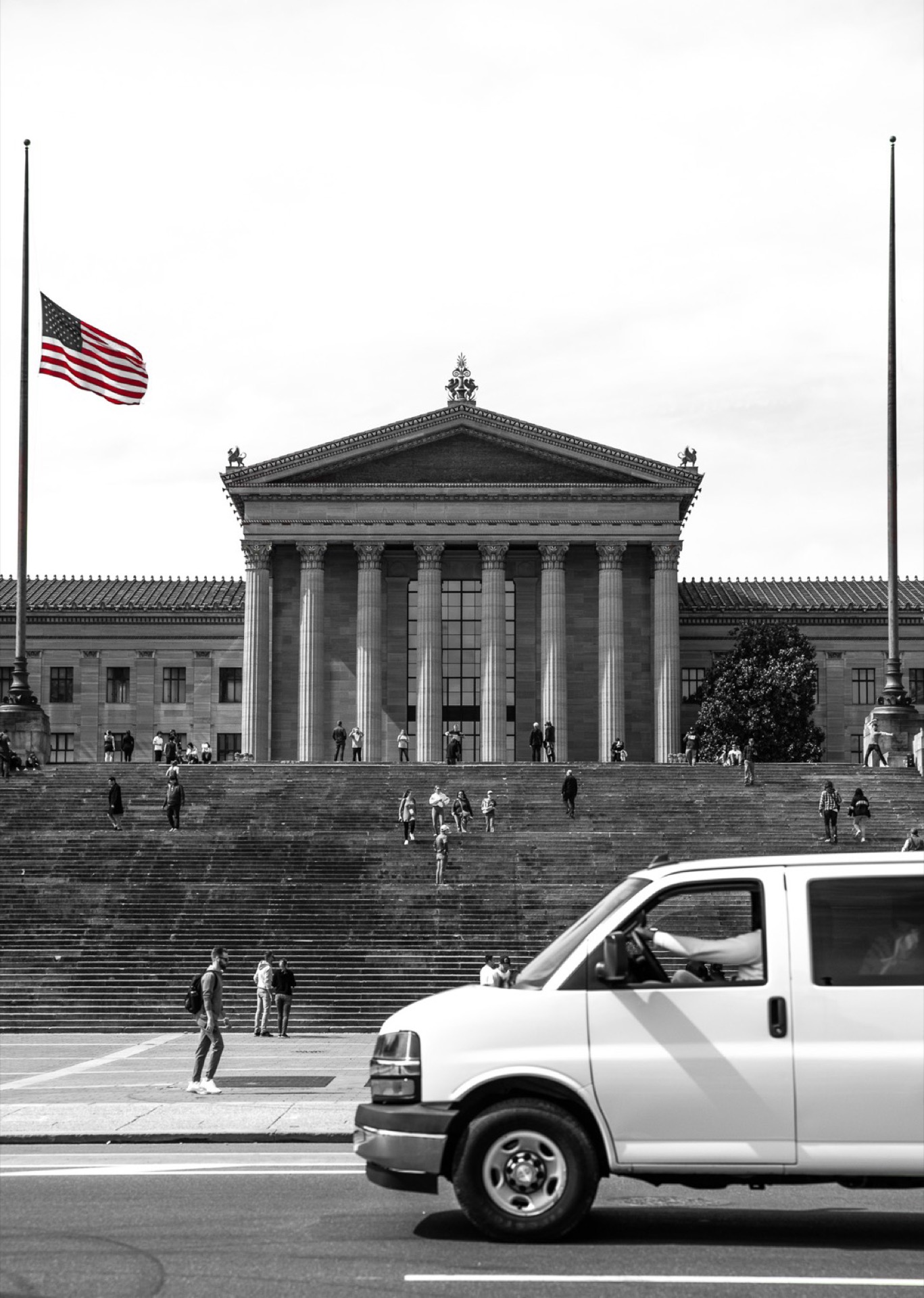 Philadelphia Museum of Art steps with American flag at half-mast, black and white